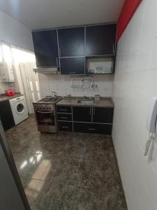 a small kitchen with a sink and a stove at Depto Caba Floresta in Buenos Aires +2 photos