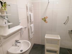 a white bathroom with a sink and a mirror at L-Appartements in Burgau