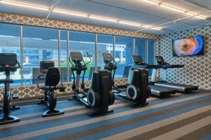 a gym with treadmills and elliptical machines at Aloft Richardson in Richardson