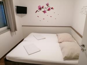 Bett in einem Zimmer mit Blumen an der Wand in der Unterkunft L-Appartements in Burgau