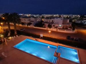 uitzicht op een zwembad in de nacht bij Mar a Vista in Albufeira