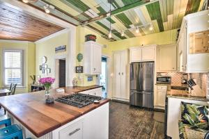 a kitchen with white cabinets and a wooden counter top at Historic Galveston Hideaway, Walk to the Beach! in Galveston