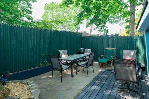 un patio con mesa, sillas y una valla en The Hampton Sack, en East Hampton