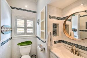 a bathroom with a toilet and a sink and a mirror at Historic Galveston Hideaway, Walk to the Beach! in Galveston +29 photos