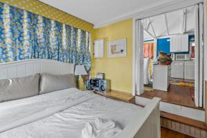 1 dormitorio con 1 cama blanca grande y cocina en The Hampton Sack, en East Hampton