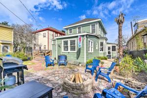 a yard with blue chairs and a house at Historic Galveston Hideaway, Walk to the Beach! in Galveston