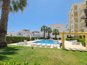 een zwembad met ligstoelen en een resort bij Mar a Vista in Albufeira