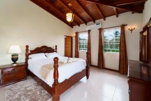 a bedroom with a bed and a dresser and windows at Ferron House in Saint James