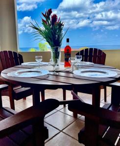 una mesa de madera con platos y un jarrón de flores. en Ferron House, en Saint James