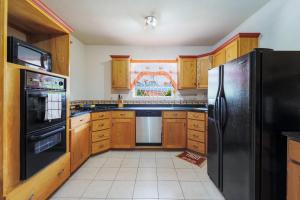 聖詹姆斯的住宿－Ferron House，厨房配有木制橱柜和黑色冰箱。
