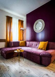 un sofá púrpura en una sala de estar con espejo en My Place Apartments de Luxe, en Split