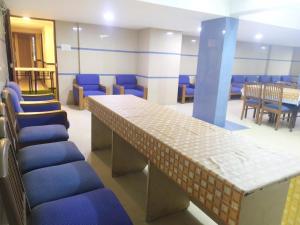 ein Wartezimmer mit blauen Stühlen und einem Tisch in der Unterkunft Hotel Ashok Tuliip Bhiwandi in Thane