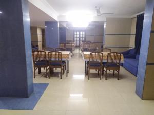 ein Esszimmer mit einem Tisch, Stühlen und einem blauen Sofa in der Unterkunft Hotel Ashok Tuliip Bhiwandi in Thane