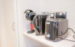 a counter with two coffee makers on a shelf at Flat in London in London