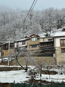 uma casa numa colina com neve no chão em La Indefinida em Toranzo