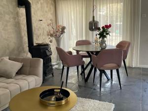 een woonkamer met een tafel en stoelen en een bank bij Charmant, ontspannen Molenzicht in Ootmarsum