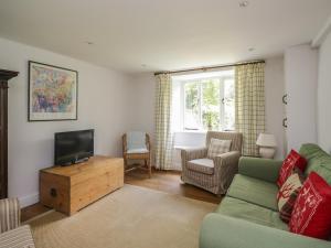 a living room with a couch and a flat screen tv at Hall Bank Cottage in Rydal