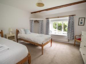 a bedroom with two beds and a window at Hall Bank Cottage in Rydal