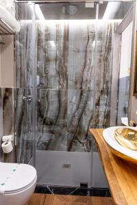 a bathroom with a shower with a toilet and a sink at Queen Cattleya Suite in Genoa +98 photos