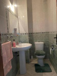 ein Badezimmer mit einem Waschbecken, einem WC und einem Spiegel in der Unterkunft Apartment soultana in Tangier