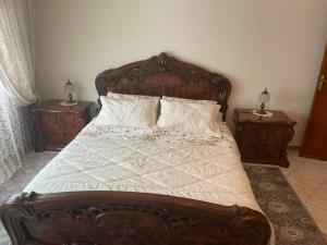 ein Schlafzimmer mit einem Holzbett mit zwei Nachttischen in der Unterkunft Apartment soultana in Tangier