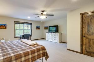 a bedroom with a bed and a ceiling fan at Contemporary Gull Lake Resort Townhome Boat Slip! in Nisswa