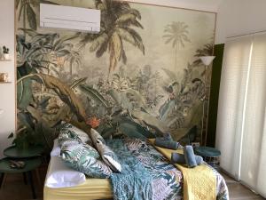 a bedroom with a tropical mural on the wall at Guest house arboré in Saint-Loubès