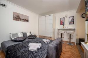 a bedroom with a bed and a couch in it at Apartment PEACE in Trebinje