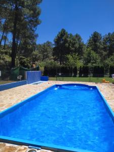 a large blue swimming pool in a yard at El Rincón de María. in Riópar