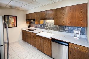 a kitchen with wooden cabinets and a sink and a dishwasher at Kahler Inn and Suites in Rochester