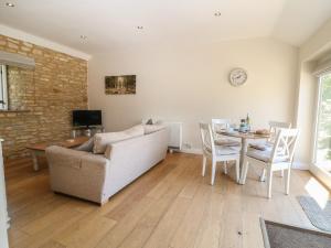 a living room with a couch and a table at Saddlebacks Barn in Burford