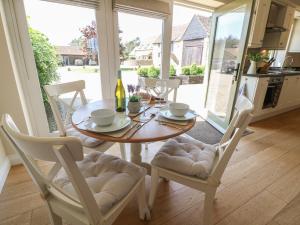 a dining room table with two chairs and a bottle of wine at Saddlebacks Barn in Burford