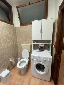 a bathroom with a toilet and a washing machine at Don Concetto in Marzamemi