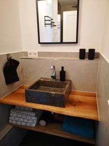 a bathroom with a sink on a wooden shelf at Ferienwohnung Lieblingszeit in Unterwössen