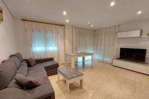 - un grand salon avec un canapé et une table dans l'établissement Apartamento en urbanización lujo, à Tavernes de Valldigna