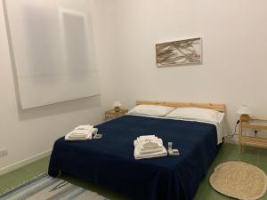 una camera da letto con un letto blu e asciugamani di Villa Egiza con piscina e accesso diretto al mare a Carini