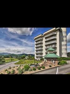 a large building with a green roof next to a road at Amazing Mountain Views, 5 min to Dollywood&parkway in Pigeon Forge