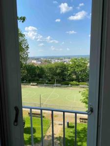 a view of a tennis court from a window at Appartement familial Wifi Netflix Amazon Prime in Saint-Cyr-lʼÉcole
