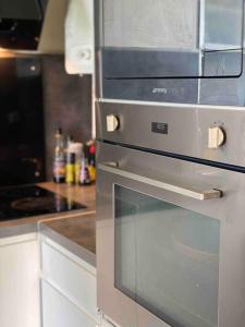 a kitchen with a glass oven in a kitchen at Appartement familial Wifi Netflix Amazon Prime in Saint-Cyr-lʼÉcole