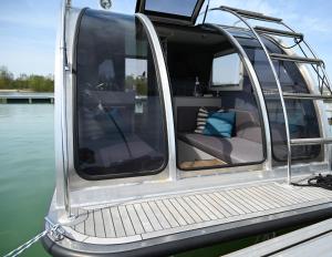 a white boat with the door open on the water at Wohnen auf der Marina Lagovida, Hausboot mit Sonnenterrassen auf 20 qm in Großpösna