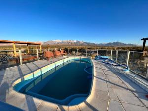 a swimming pool on top of a building with mountains in the background at Naol village in Uspallata