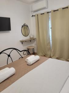 - une chambre avec un lit et 2 serviettes dans l'établissement Houlia home διαμέρισμα με δωρεάν χώρο στάθμευσης, à Andros