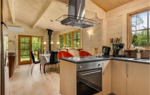 a kitchen with a stove top oven next to a table at Two-Bedroom Holiday Home In Herning in Herning