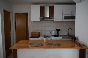 Apartman Milutin في فرسي: مطبخ بدولاب بيضاء وقمة كونتر خشبي