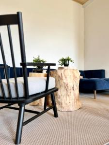 a black chair in a living room with a table and a tree stump at Smiðjan - main road Stykkishólmi in Stykkishólmur