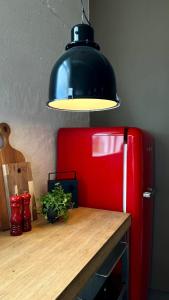 a table with a red refrigerator and a lamp at Smiðjan - main road Stykkishólmi in Stykkishólmur