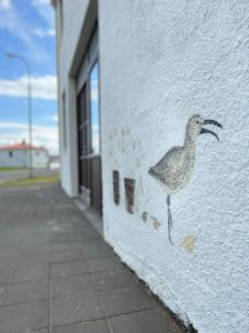 uma pintura de um pássaro na lateral de um edifício em Smiðjan - main road Stykkishólmi em Stykkishólmur