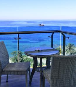 a table and chairs on a balcony with the ocean at Azura Deluxe Resort & Spa - Ultra All Inclusive in Avsallar