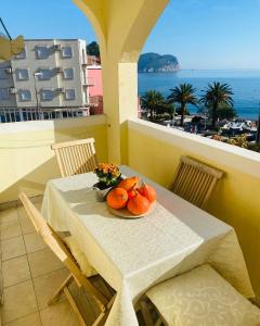 a table with a plate of oranges on a balcony at Miomir Perazic Apartments in Petrovac na Moru