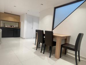 a kitchen and dining room with a table and chairs at Palmera City apartment in Novi Sad